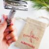 Albatross brand eco friendly plastic-free stainless steel flagship butterfly safety razor in hand with small sustainable Albatross burlap bag