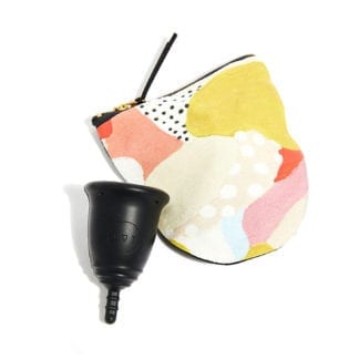 Dot For All brand silicone menstrual cup in black, shown next to zippered carrying pouch