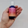 Frontside display of eco friendly Captain Blankenship organic grapefruit and palmarosa sea mineral liquid soap in reusable two ounce blue bottle held in hand.