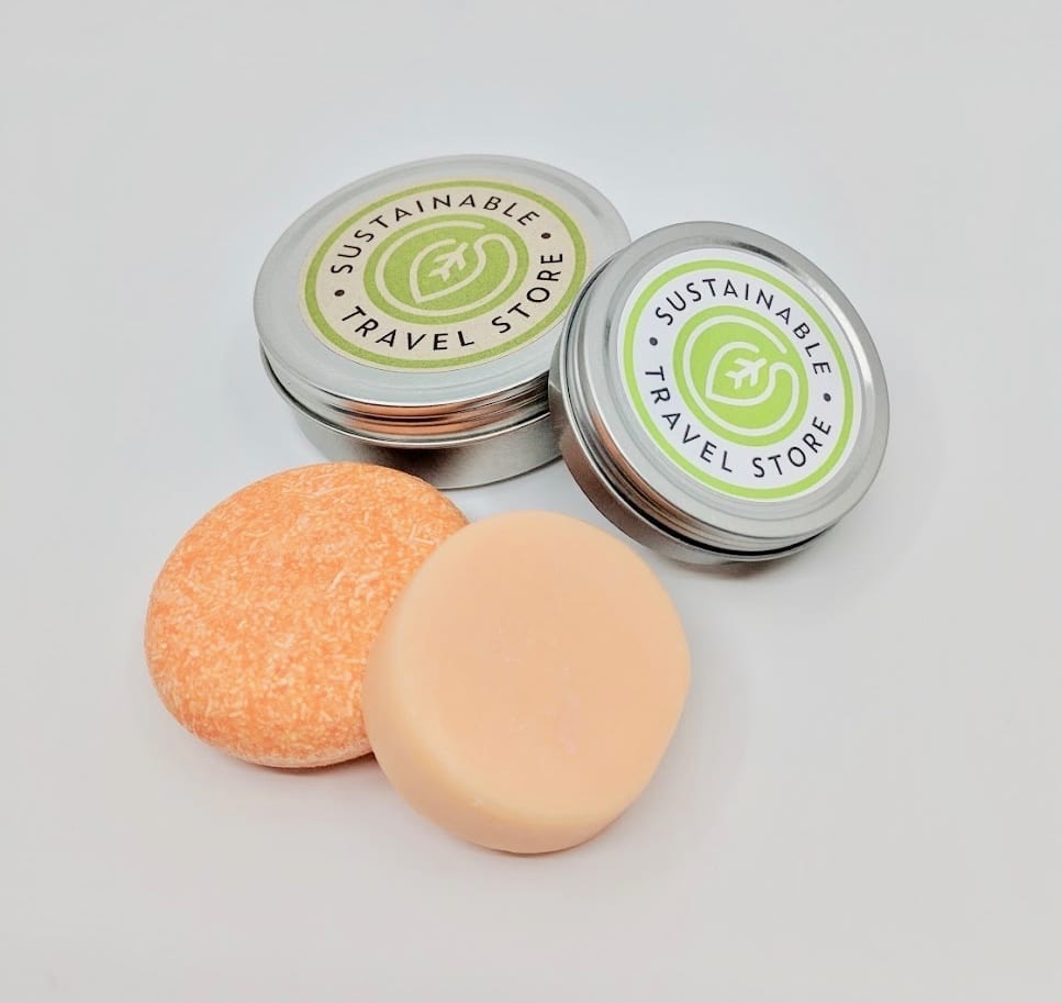 Pink Maverick brand solid shampoo and conditioner bars with tangerine and lemon scent; each bar comes with its own reusable travel tin