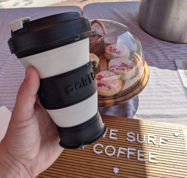 Eco-friendly collapsible Pokito coffee cup at a market coffee booth