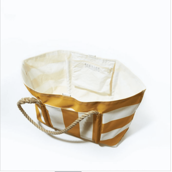 Interior of the Sea Bags brand large beach tote with white and yellow stripes; shows large exterior pocket and zippered interior pocket