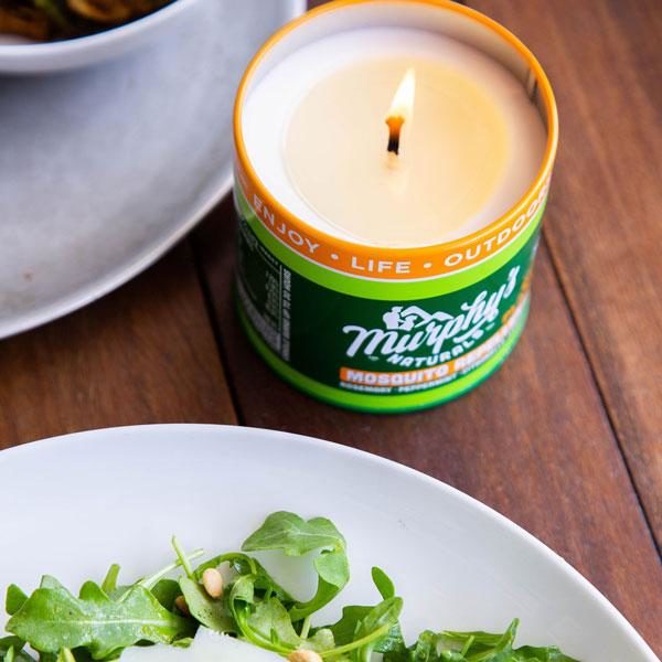 Deet-free natural bug repellant candle on table with salad