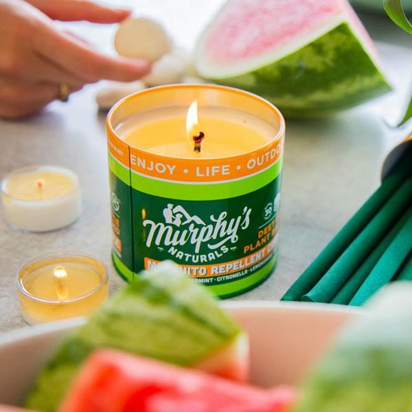 Deet-free bug repellant candle from Murphys Natural on table with watermelon