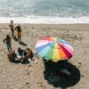 Overhead view of group at beach with sustainable travel festival blanket mat in baja aqua
