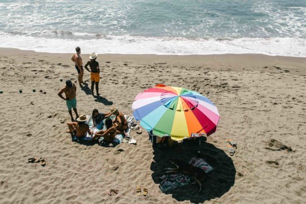 Overhead view of group at beach with sustainable travel festival blanket mat in baja aqua