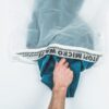 Reaching into eco friendly Guppyfriend brand anti-microplastic laundry bag to pull out clothing.