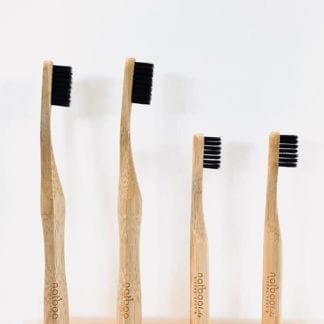 Two adult and two child sized Natboo brand biodegradable bamboo toothbrushes with black activated charcoal infused bamboo bristles