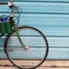 Side display of eco friendly Green Guru Gear brand Sixer 6-pack Top Tube Holder, loaded up with bottle brews, mounted on dark green bike.  Product is made from upcycled bicycle inner tubes, repurposed nylon fabric, and 18oz vinyl waterproof tarp.