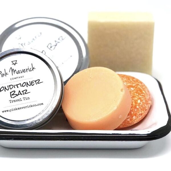Pink Maverick brand solid shampoo and conditioner bars with tangerine and lemon scent; each bar comes with its own travel tin