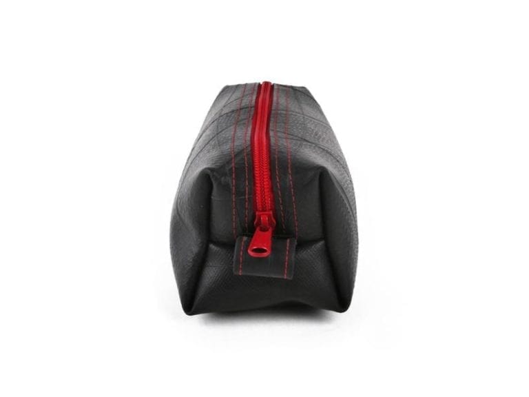 Small dopp kit by Alchemy Goods made of durable upcycled inner tubes; shown in black with red zipper.