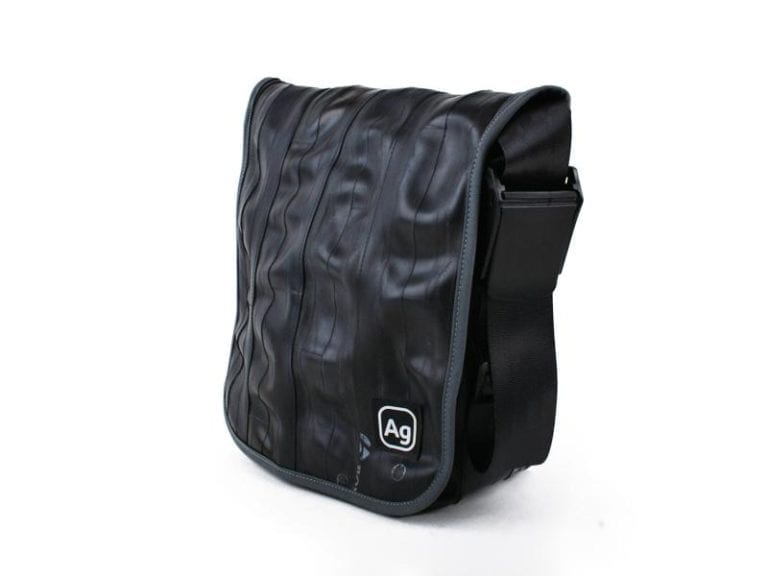 Small shoulder bag by Alchemy Goods made from upcycled bicycle inner tubes; side view to show adjustable shoulder strap.