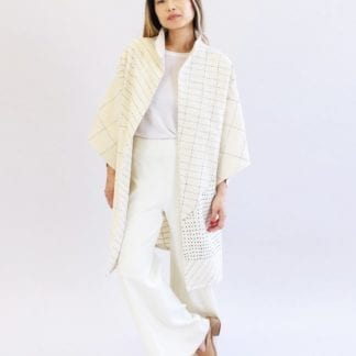 Woman wearing a sustainable handmade long kimono canvas jacket in bone white made by Anchal brand.