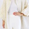 Close up of woman wearing a sustainable handmade long kimono canvas jacket in bone white made by Anchal brand.