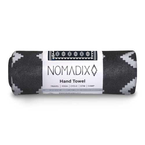 Product display of sustainably made Nomadix brand, Boulder Midnight pattern, recycled hand and gym towel rolled up in zero waste packaging.