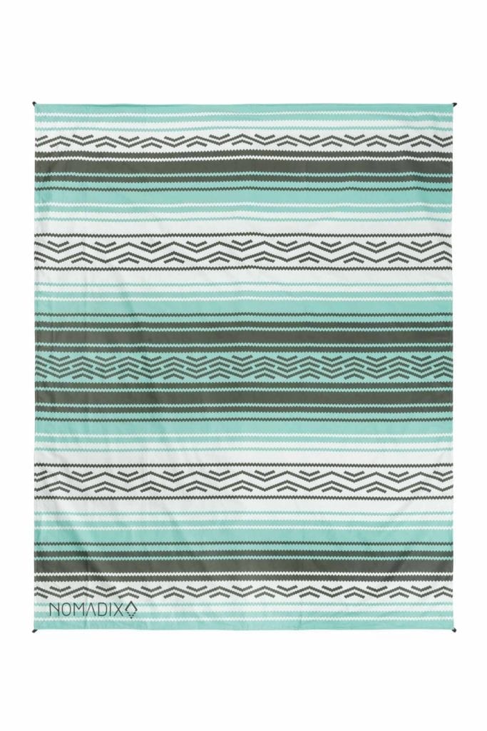 Product display of sustainably made Nomadix brand recycled soft and waterproof large festival blanket in a green and white Bajaaqua pattern.