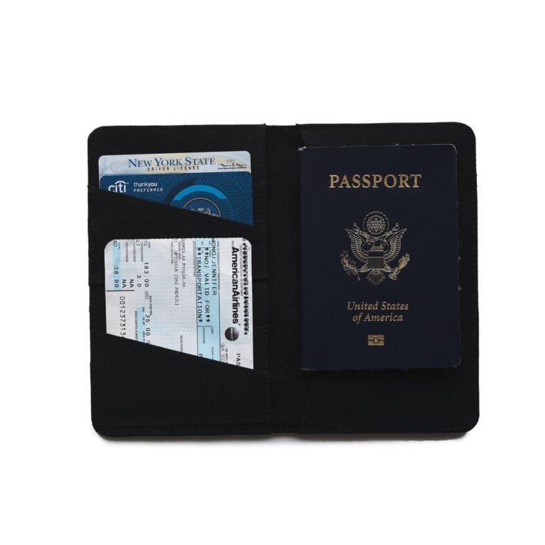 Global Goods Partners brand passport holder in black; interior shown with multiple pockets for passport, ID, and other documents