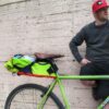 Male posing next to Multicolor upcycled fabric Green Guru Gear brand Haluer Seat Bag Bike Pack displayed in mounted position on light green Surly gravel bike with brown leather seat.