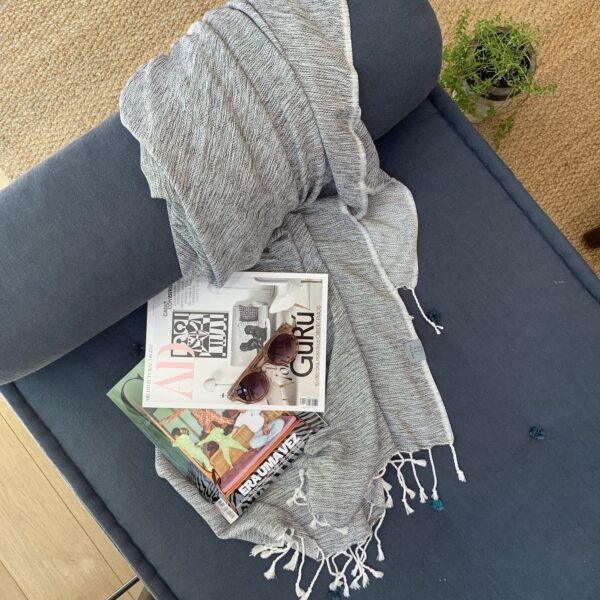 Hilana brand ultra-soft, eco friendly black Yalova blanket/throw displayed on sofa lounger.