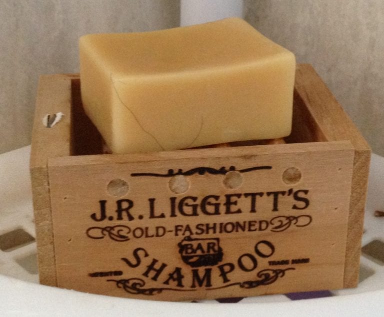 J.R. Liggett's brand sustainable Old Fashioned Shampoo Bar unwrapped on wooden crate.