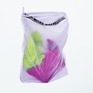 Earth friendly Guppyfriend brand anti-microplastic laundry bag with clothing inside.