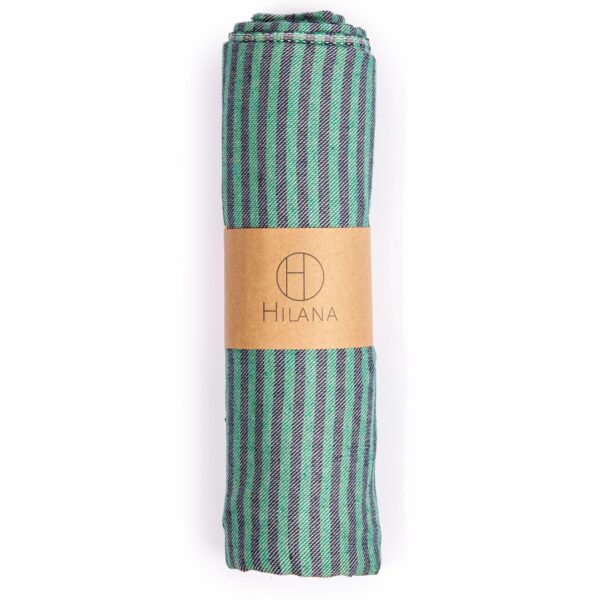 Hilana brand eco friendly green and blue striped Fethiye Towel tightly rolled with recycled paper wrap; made with environmentally friendly regenerative cotton.