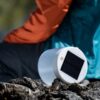 Inflatable, solar powered light sitting next to hiker