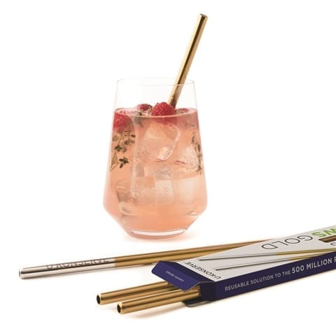 Reusable plastic free stainless steel drinking straws with gold accent in fruity cocktail with pack of three more stainless steel straws in front of drink. Straws made by U-Konserve brand.
