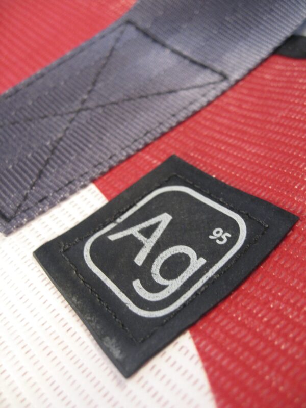 Detail showing upcycled seat belt strap and AG logo on the Alchemy large tote bag