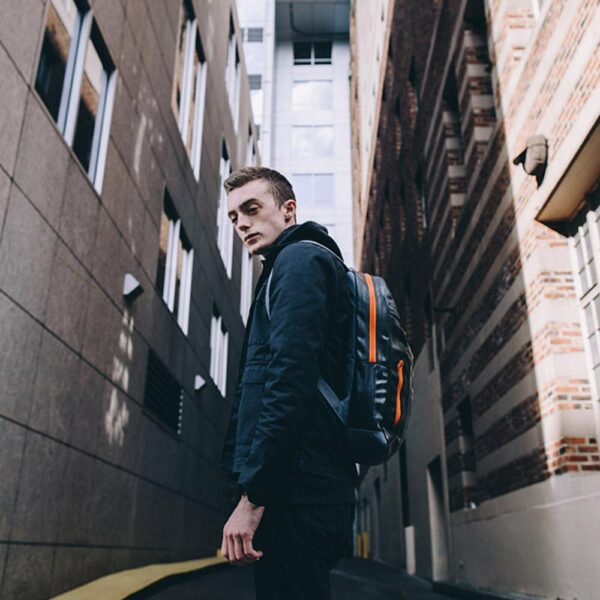 Male wearing the Alchemy Goods Brooklyn backpack with slim profile.