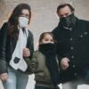 Family of three all wearing eco friendly G95 brand BioScarf air filtration warm weather protection as they are outside in the woods.