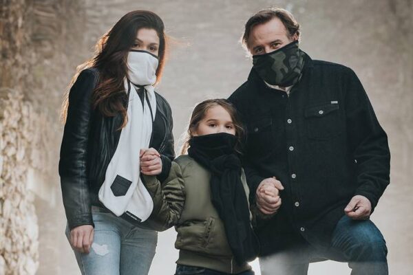 Family of three all wearing eco friendly G95 brand BioScarf air filtration warm weather protection as they are outside in the woods.