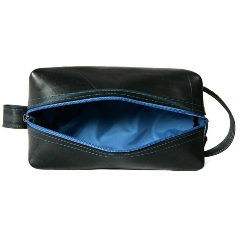 View of the large dopp kit from the top with unzipped zipper; shown in black with blue zipper and liner.