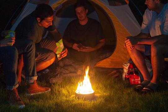 Four friends camping around Radiate Recycled Portable Campfire