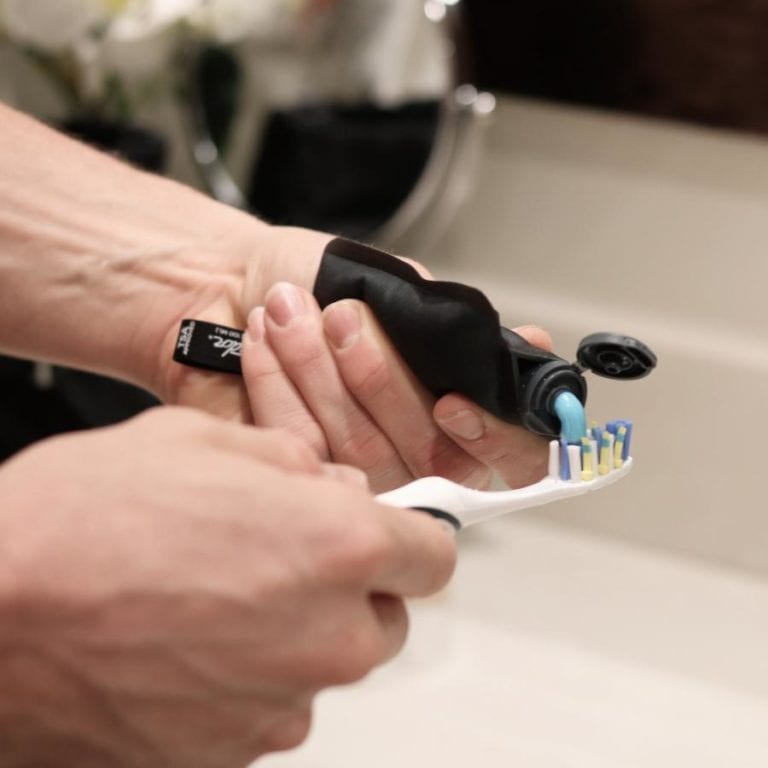 Environmentally friendly Matador FlatPak reusable toiletry bottle pictured squeezing out toothpaste onto toothbrush.