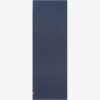 Manduka brand natural rubber 4mm yoga mat in midnight blue; shown unrolled