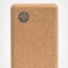 Close-up of Manduka brand travel yoga block, made with a lighter weight and sustainable cork material
