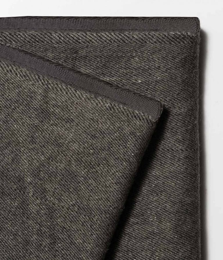 Close-up of Manduka brand wool blanket in sediment gray; made with 100% recycled fibers