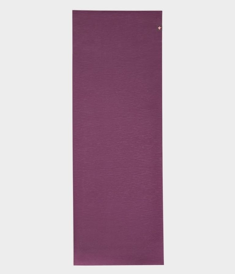 Manduka brand natural rubber 4mm yoga mat in acai purple; shown unrolled