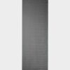 Manduka brand natural rubber 1.5mm travel yoga mat in charcoal gray; shown unrolled