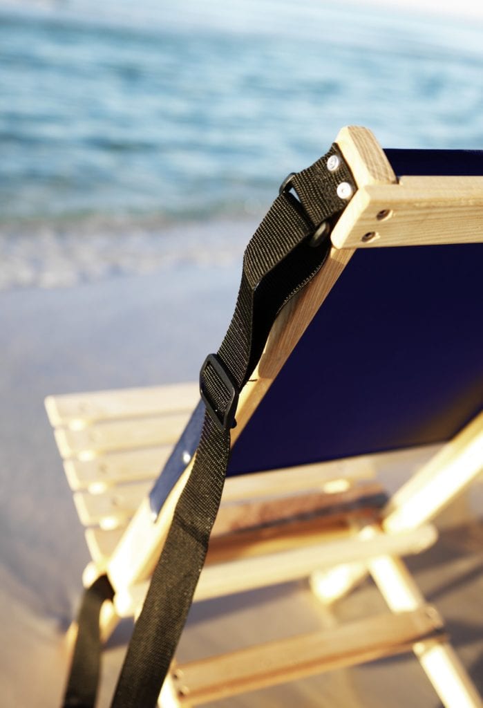 Close up display of black adjustable shoulder strap mounted on left side of sustainable Blue Ridge Chairs brand American ash Blue Ridge navy blue camping chair.