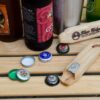 Two eco friendly Blue Ridge Chairs brand American Ash upcycled cap lifter bottle opener with six bottle caps and beer bottles all on foldable Carolina snack table.