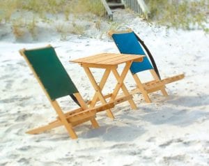 Product display for two eco friendly Blue Ridge Chairs brand American ash Blue Ridge Atlantic Blue and forest green camping chairs with a Blue Ridge folding side table in themiddle of them pictured outside on the beach.