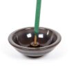 Murphy's Naturals brand circular ceramic incense stick holder; shown holding a Murphy's Naturals mosquito repellent incense stick