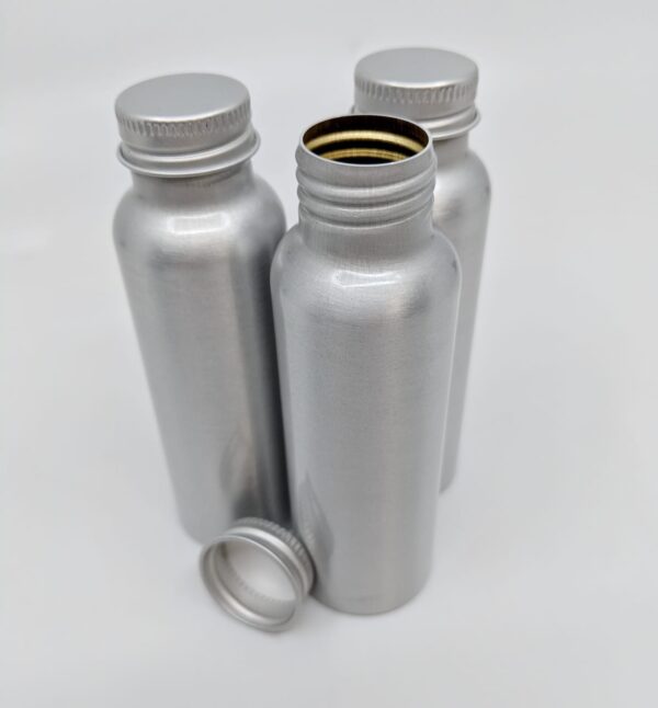 Close up display of earth friendly reusable tin container bottles that make up Reusable TSA-Friendly Travel Container Set.