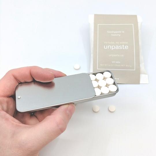 View of eco-friendly toothpaste tablets with a travel slider tin