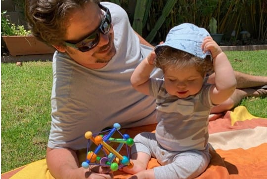 Dad with baby on recycled eco friendly Nomadix towel.