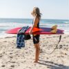 Surfer on beach with recycled Poncho Towel in Agua Blue