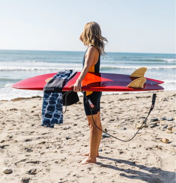 Surfer on beach with recycled Poncho Towel in Agua Blue