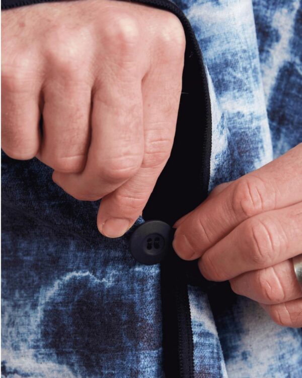 Close up of hands on side button of Agua Blue Poncho Towel for beachwear